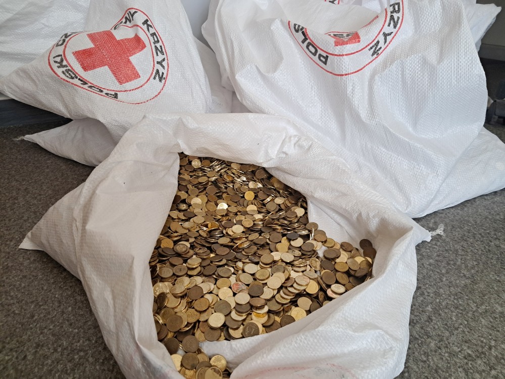 Worki z logo PCK zawierające dużą ilość złotych monet