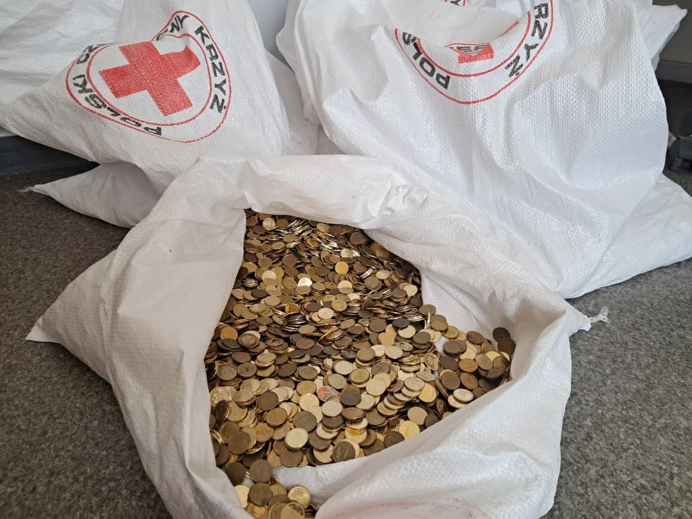 Worki z logo PCK zawierające dużą ilość złotych monet