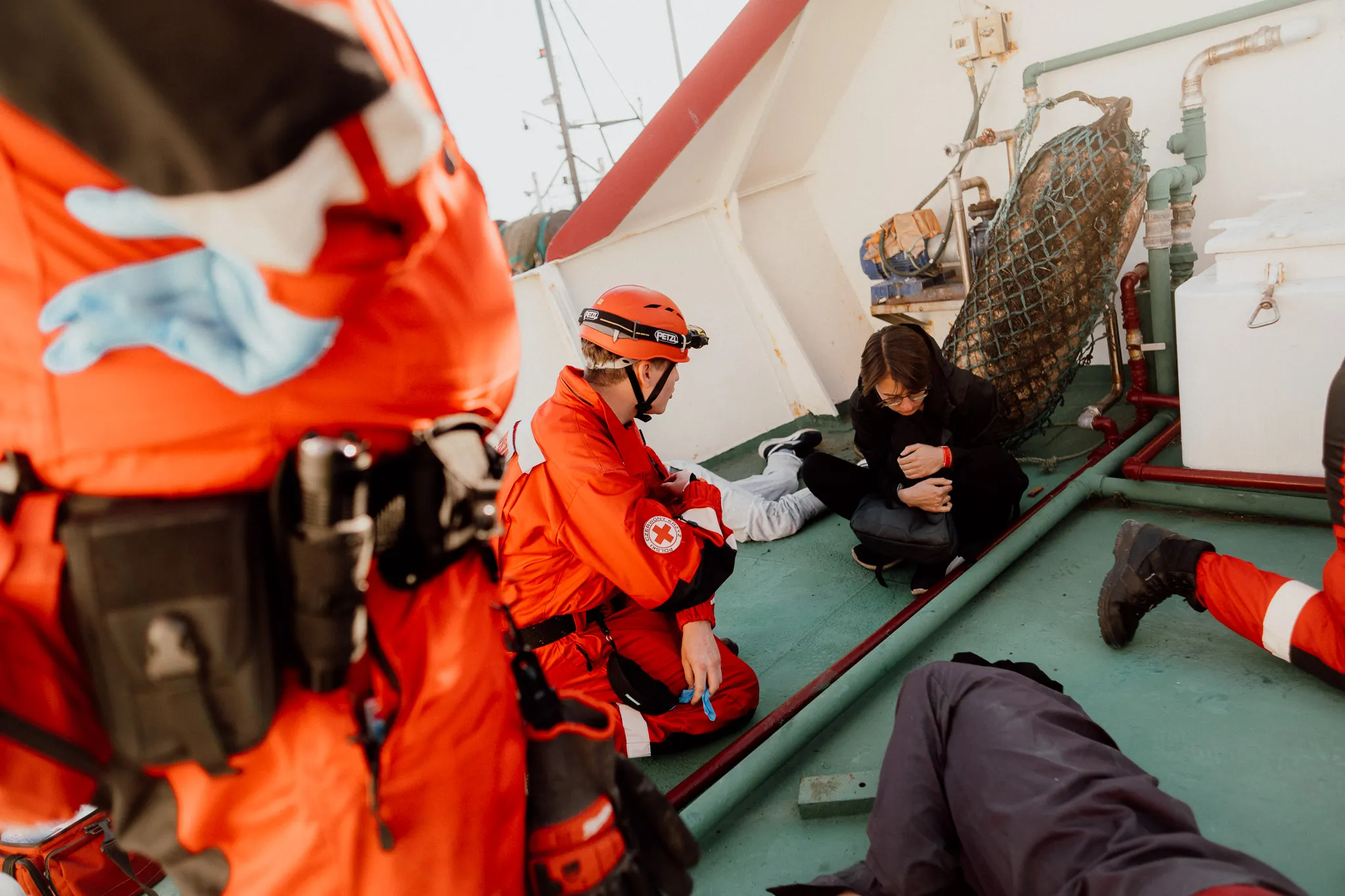 Ratownik PCK rozmawia ze smutną, ubraną na czarno nastolatką